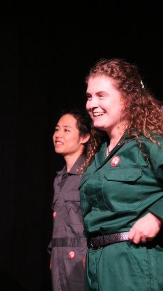 A group of young women sitting in the bleachers at a theatre