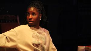 A young woman on stage pointing